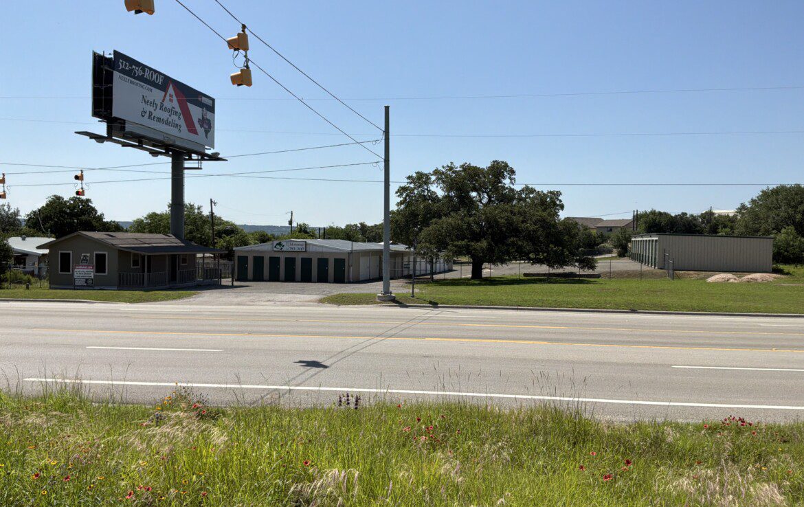 Roadside view with billboard and buildings.